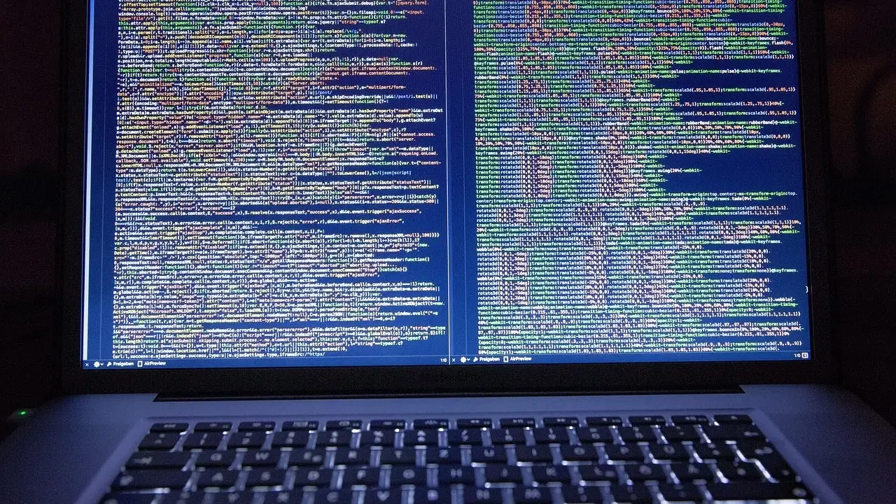 Laptop z otwartym kodem HTML i CSS na ekranie.
