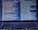 Laptop z otwartym kodem HTML i CSS na ekranie.