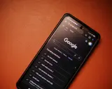 Smartfon z włączoną wyszukiwarką Google i listą popularnych wyszukiwań.