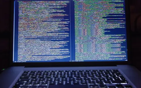 Laptop z otwartym kodem HTML i CSS na ekranie.