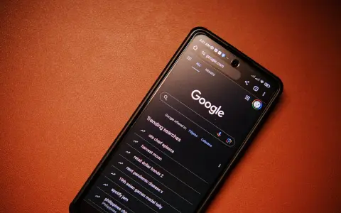Smartfon z włączoną wyszukiwarką Google i listą popularnych wyszukiwań.