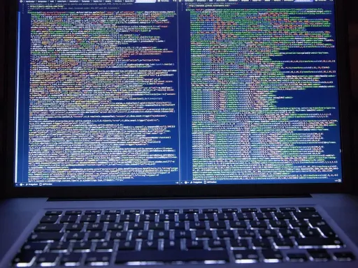 Laptop z otwartym kodem HTML i CSS na ekranie.