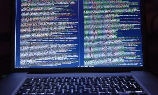 Laptop z otwartym kodem HTML i CSS na ekranie.