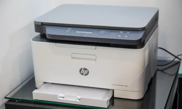 Drukarka HP Color Laser MFP 178nw na szklanej półce.