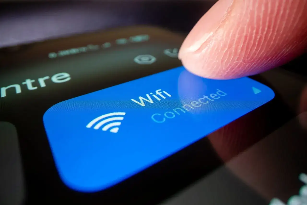smartfon z ikoną ustawień i symbolem Wi-Fi